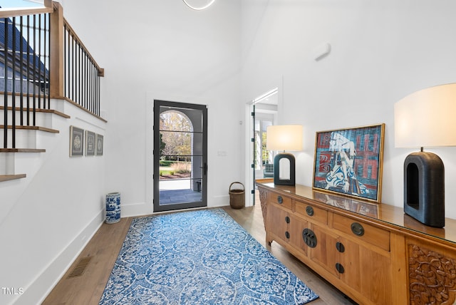 foyer with a towering ceiling and light hardwood / wood-style floors