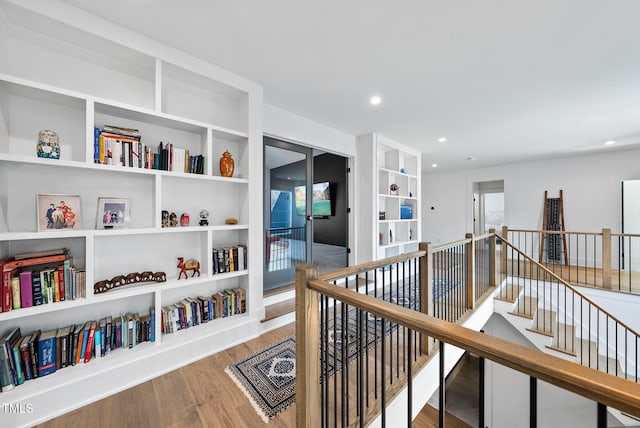 hall with plenty of natural light and hardwood / wood-style flooring