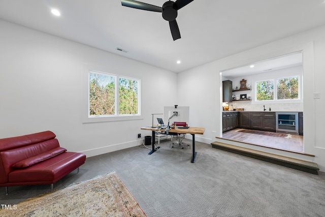 office space with wine cooler, ceiling fan, and carpet