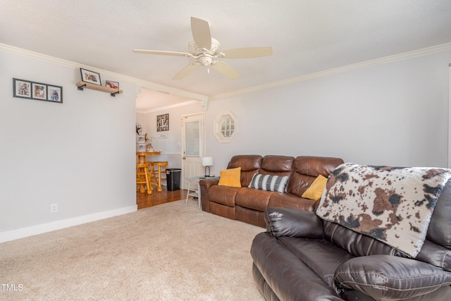 carpeted living room featuring ceiling fan and crown molding