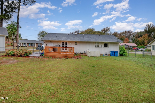 rear view of property with a lawn and a deck