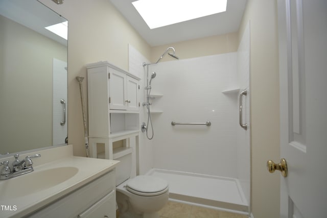 bathroom with vanity, tile patterned floors, a skylight, toilet, and tiled shower