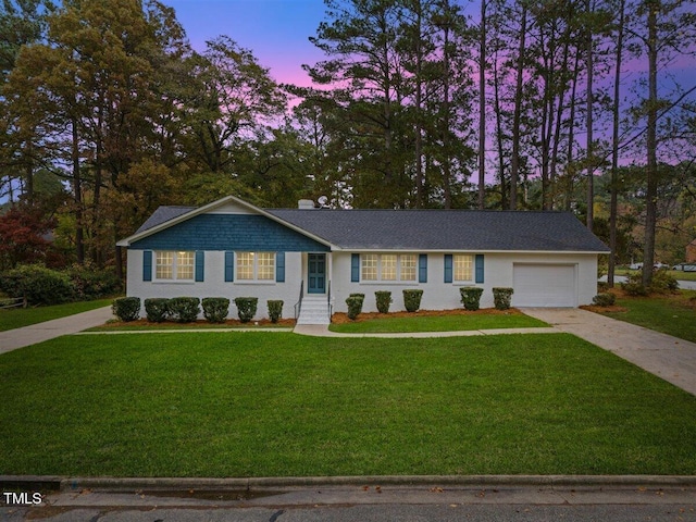 ranch-style house featuring a yard and a garage