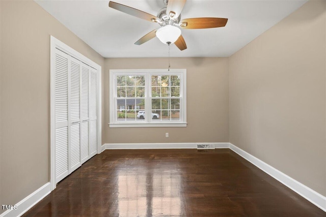 unfurnished bedroom featuring dark hardwood / wood-style flooring, a closet, and ceiling fan