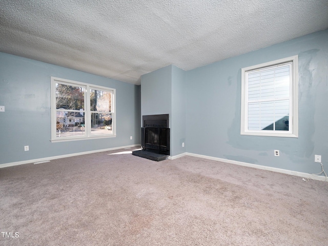 unfurnished living room featuring carpet and a textured ceiling