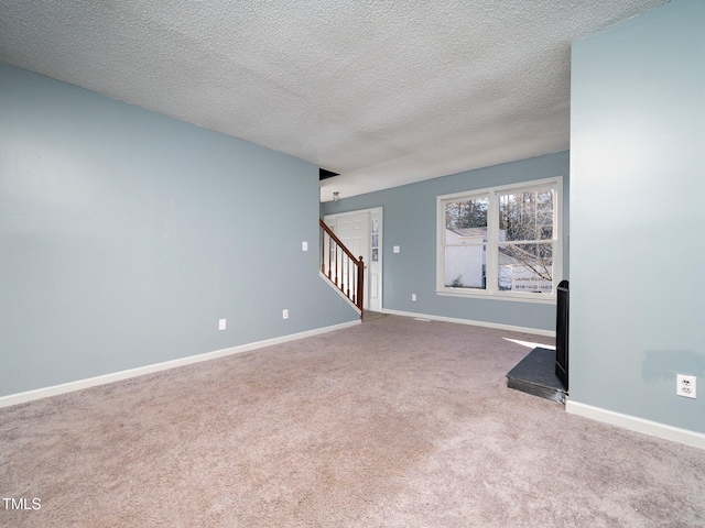 unfurnished living room with carpet flooring and a textured ceiling