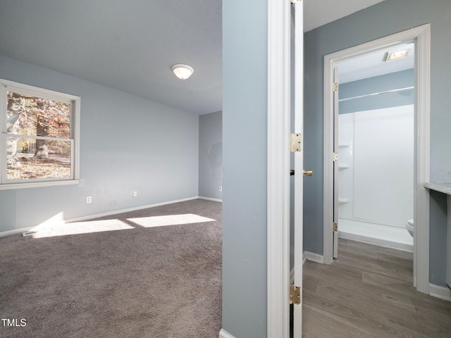 spare room featuring dark colored carpet