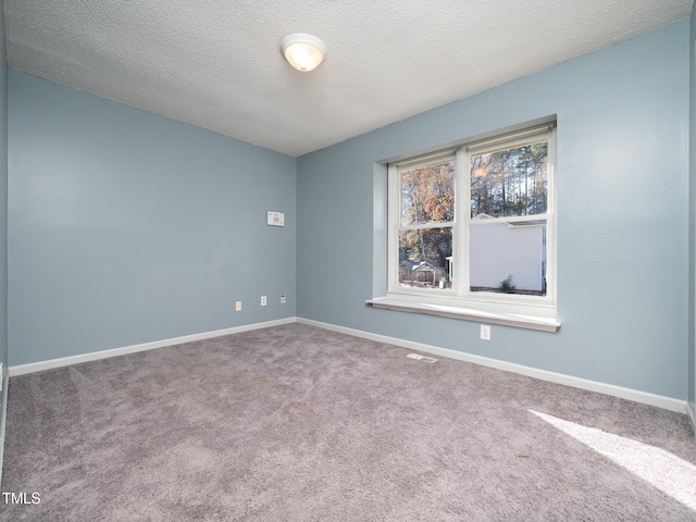 carpeted spare room with a textured ceiling