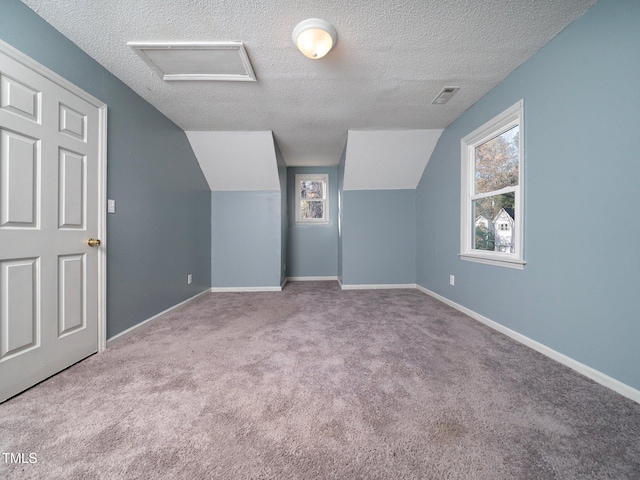 bonus room with a textured ceiling, light colored carpet, and lofted ceiling