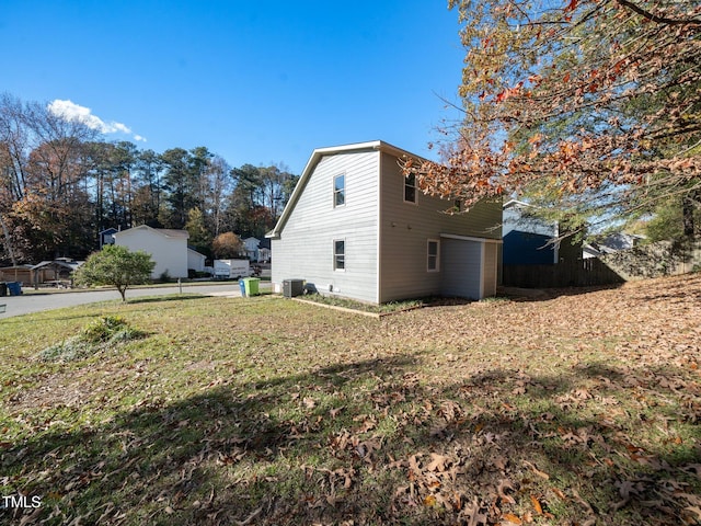 view of side of property with central AC and a lawn