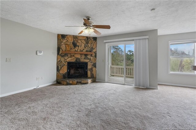 unfurnished living room with carpet flooring, a wealth of natural light, and a textured ceiling