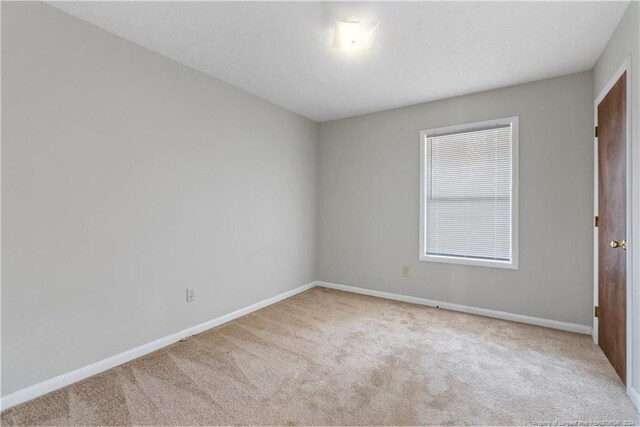 spare room featuring light colored carpet