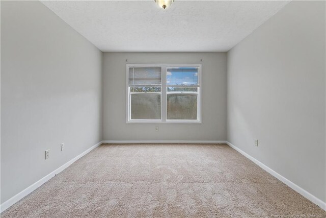 carpeted empty room with a textured ceiling