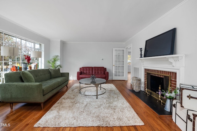 living room with a fireplace, ornamental molding, and dark wood-type flooring