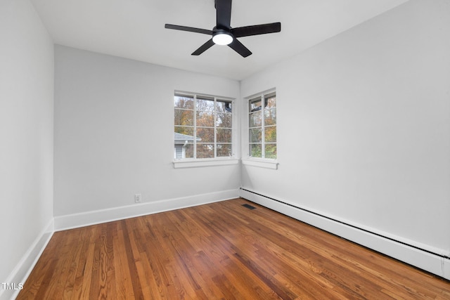 spare room with ceiling fan, wood-type flooring, and baseboard heating