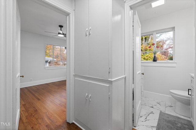 bathroom with hardwood / wood-style flooring, plenty of natural light, ceiling fan, and toilet