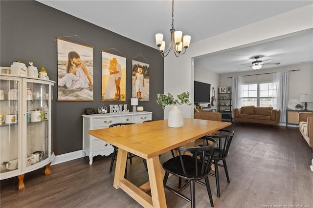 dining room featuring ceiling fan with notable chandelier and dark hardwood / wood-style floors