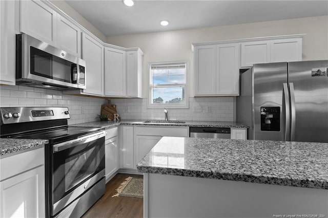 kitchen featuring backsplash, white cabinetry, sink, and appliances with stainless steel finishes