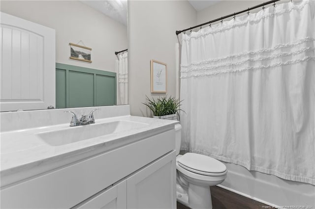 full bathroom with hardwood / wood-style flooring, shower / bath combo, toilet, and vanity