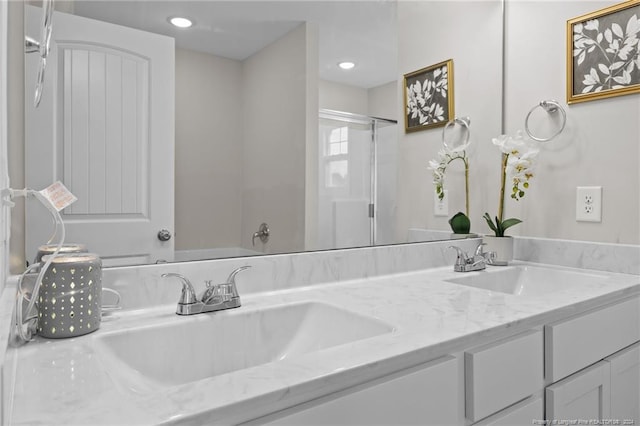 bathroom featuring a shower with door and vanity