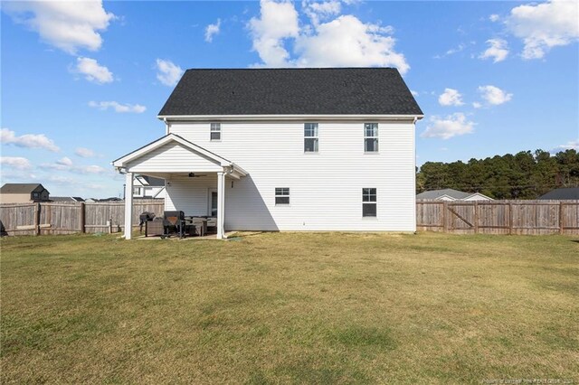 back of house with a yard and a patio