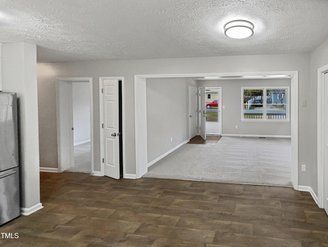 hallway with dark hardwood / wood-style floors and a textured ceiling