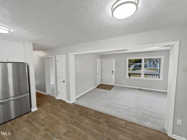 interior space with a textured ceiling and hardwood / wood-style flooring