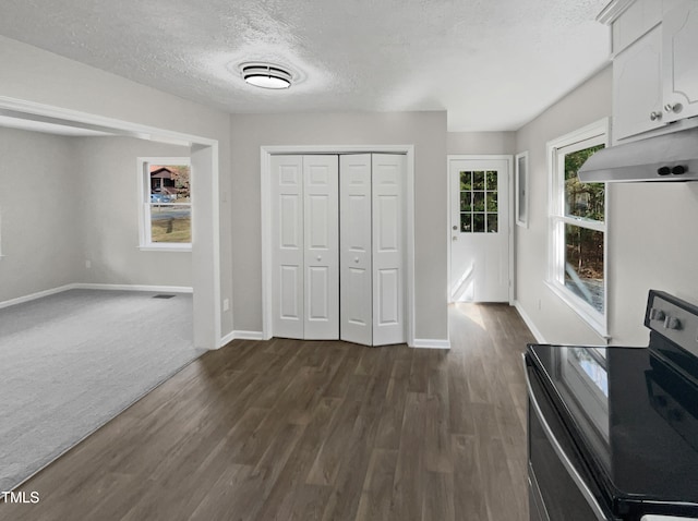 unfurnished bedroom with a textured ceiling, dark hardwood / wood-style floors, and a closet