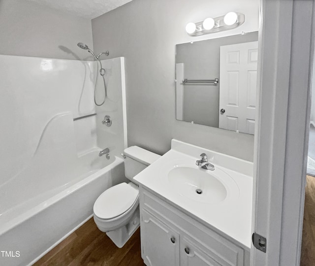 full bathroom with shower / bathing tub combination, hardwood / wood-style floors, a textured ceiling, toilet, and vanity