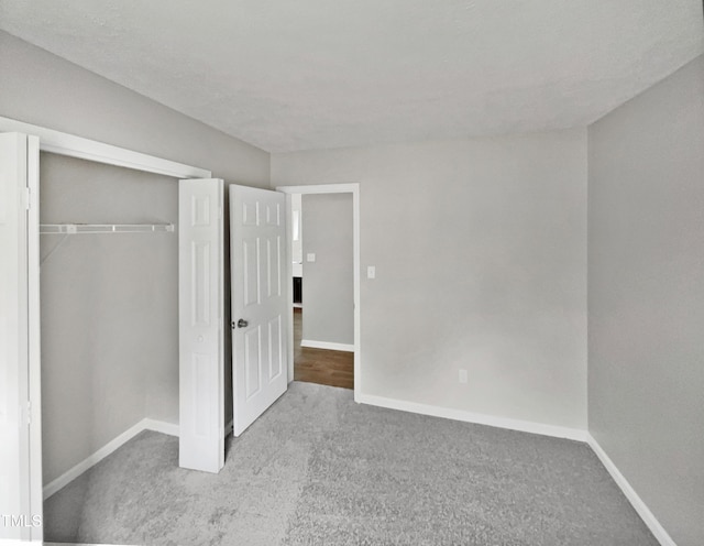 unfurnished bedroom featuring light carpet, a closet, and a textured ceiling