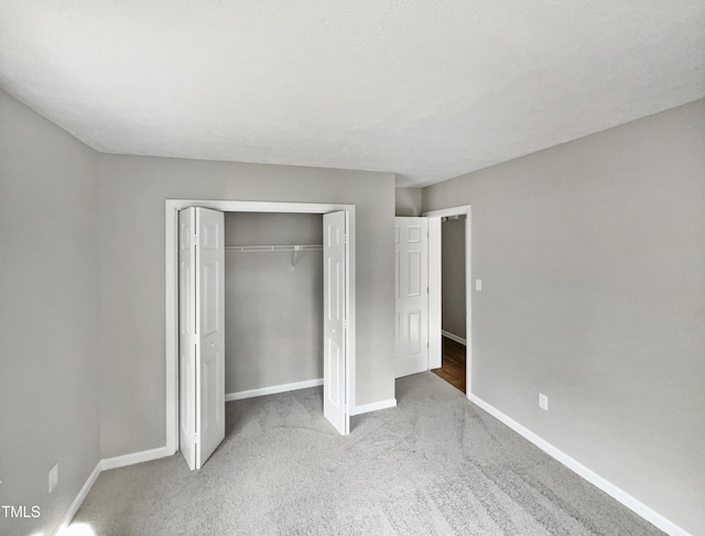 unfurnished bedroom with light colored carpet and a closet