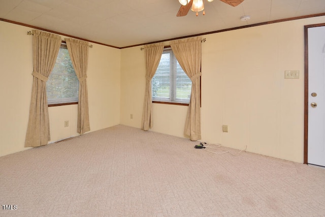 carpeted empty room featuring ceiling fan and crown molding