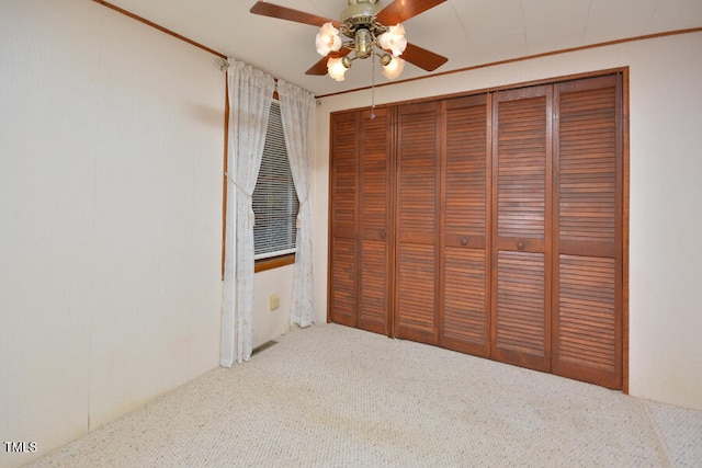 unfurnished bedroom featuring carpet, ceiling fan, and a closet