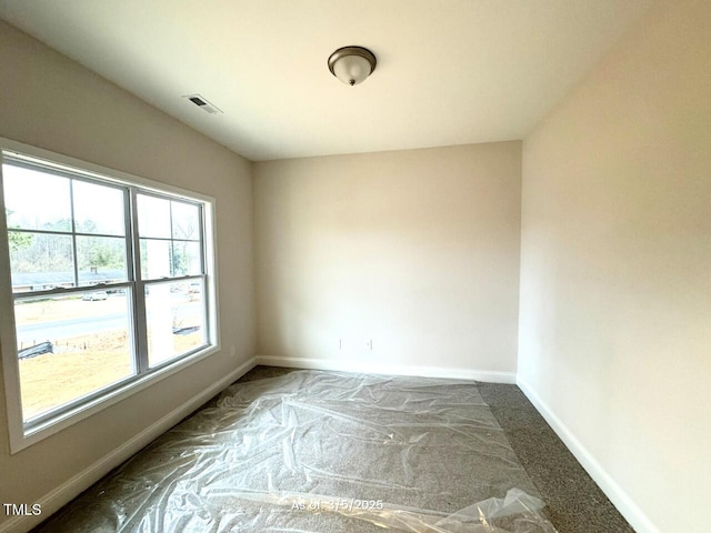 carpeted empty room featuring visible vents and baseboards