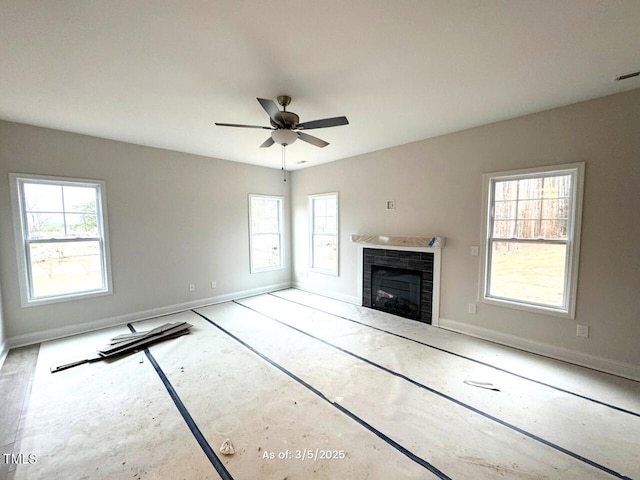 unfurnished living room with a fireplace, baseboards, and a ceiling fan