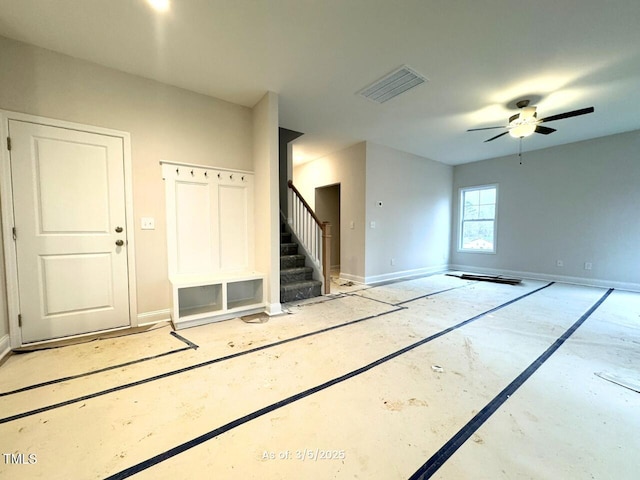 empty room featuring visible vents, baseboards, and stairs