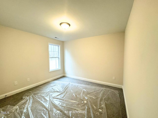 carpeted spare room with visible vents and baseboards