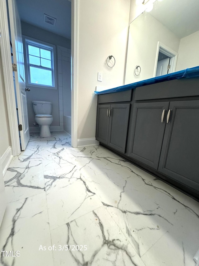 bathroom featuring marble finish floor, visible vents, toilet, vanity, and baseboards