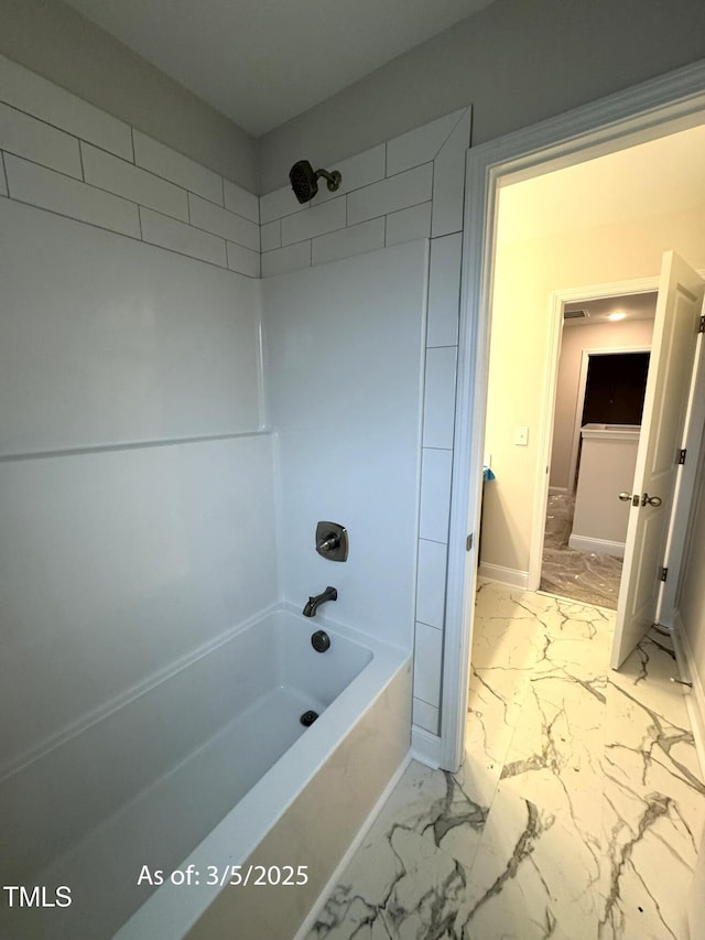 bathroom featuring marble finish floor, shower / tub combination, and baseboards