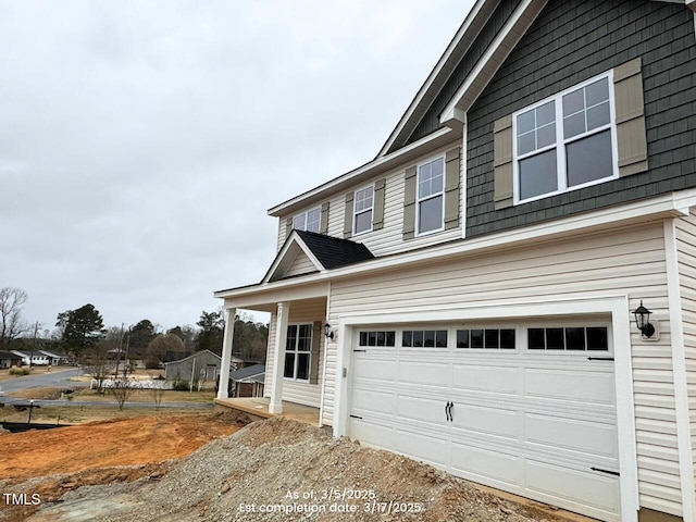 traditional-style home featuring a garage and dirt driveway