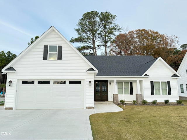 view of front of property featuring a garage, a front yard, and french doors