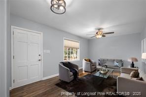 living room featuring ceiling fan and dark hardwood / wood-style flooring