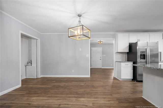 kitchen with pendant lighting, stainless steel fridge, light stone countertops, white cabinets, and dark hardwood / wood-style flooring