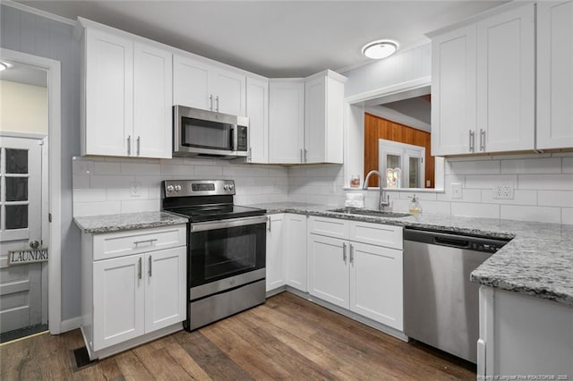 kitchen featuring white cabinetry, sink, light stone countertops, and appliances with stainless steel finishes