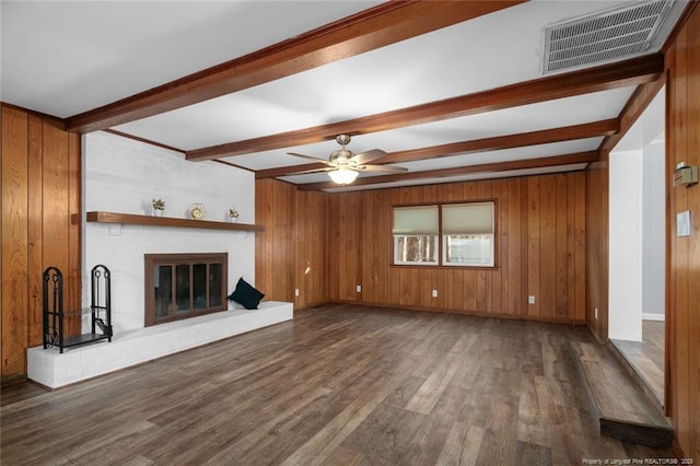 unfurnished living room featuring beamed ceiling, a fireplace, dark hardwood / wood-style floors, and wood walls