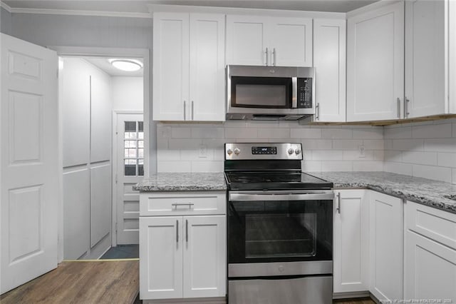 kitchen with light stone counters, crown molding, decorative backsplash, appliances with stainless steel finishes, and white cabinets