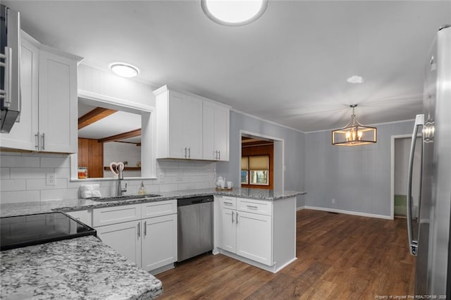 kitchen featuring white cabinets, decorative light fixtures, a peninsula, stainless steel appliances, and a sink