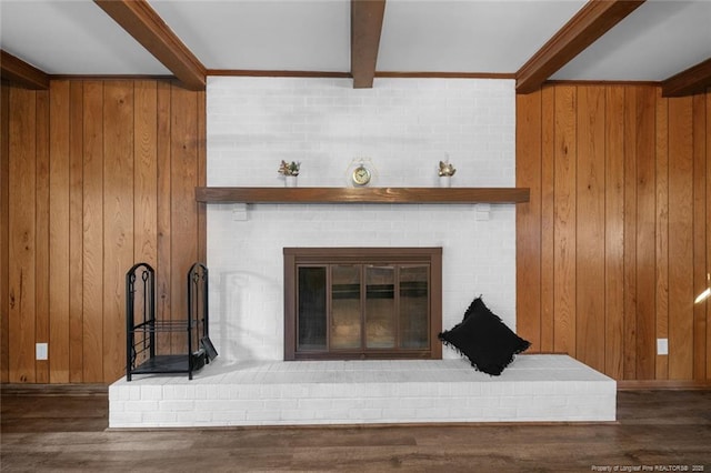 interior details with wood walls, a fireplace, wood finished floors, beam ceiling, and crown molding