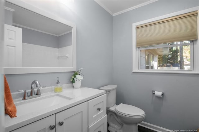 bathroom featuring baseboards, crown molding, vanity, and toilet