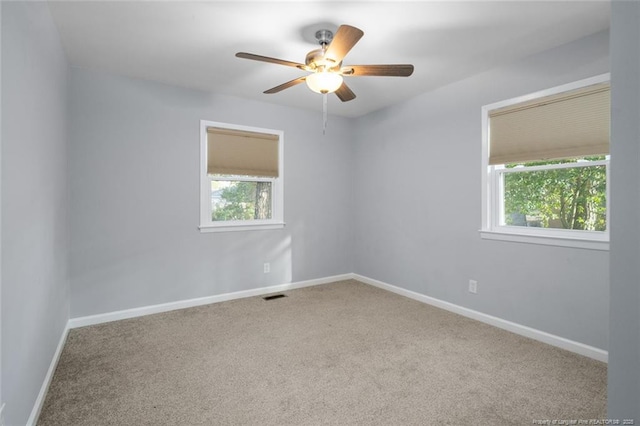 unfurnished room with light carpet, baseboards, visible vents, and a healthy amount of sunlight